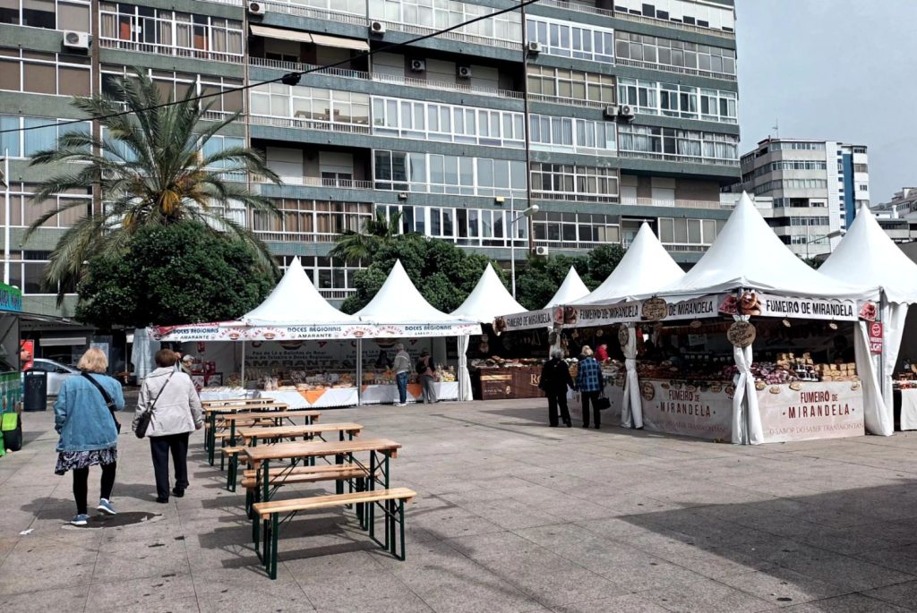 White market tents and wooden benches on a city square